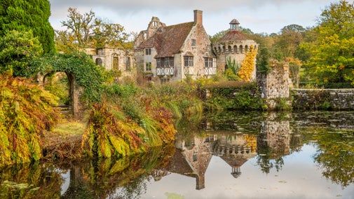 View of the Old Castle ruins through the autumnal garden at Scotney Castle, Kent